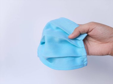 Mavi maske takan beyaz lateks eldivenli bir el. Beyaz arkaplanda izole edilmiş