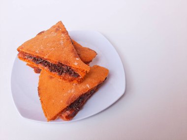 Semarang, Endonezya 'dan Kue Terang Bulan. Popüler sokak yemekleri, krepe benzer, çeşitli dolgulu (çikolata, çilek reçeli veya rafine şeker). Beyaz bir plaka üzerinde, beyaz arka planda izole edilmiş.