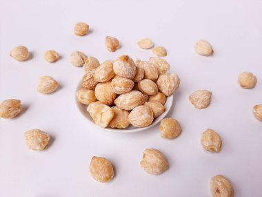 Aleurite moluccanus veya Kemiri adı verilen Endonezya Candlenuts, beyaz arka planda izole edilmiş bir smale plakasının içinde.