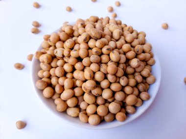 Kurutulmuş Glycine Max, soya fasulyesi veya soya fasulyesi, beyaz bir tabağın içinde, beyaz arka planda izole edilmiş.