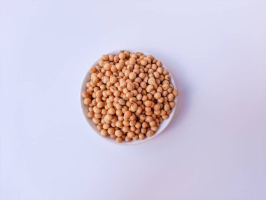 Kurutulmuş Glycine Max, soya fasulyesi veya soya fasulyesi, beyaz bir tabağın içinde, beyaz arka planda izole edilmiş.