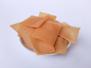 Çiğ Kerupuk terigu, ya da un krakeri, kızarmadan önce. Kare şeklinde. Endonezya yemeği ya da atıştırmalık olarak. Beyaz bir plakanın içine yerleştirilmiş, beyaz arka planda izole edilmiş.