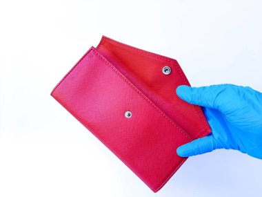 Beyaz lateks eldivenli bir el boş kırmızı bir çanta gösteriyor. Beyaz bir arkaplanda izole edilmiş