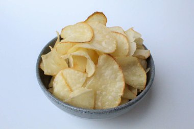 Tapyoka cipsi, ya da manyok cipsi, ya da kızartılmış manyok kökü. Gri bir kasede. Beyaz arkaplanda izole edilmiş