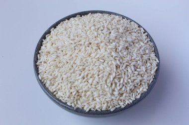 Gri kasenin içinde beyaz arka planda izole edilmiş bir pirinç yığını.