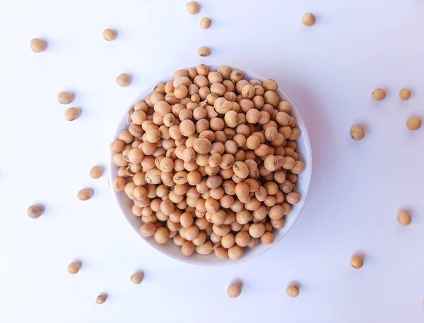 Dried Glycine max or soybean or soyabean, inside a white plate, isolated in white background