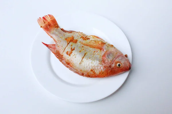 赤ナイル ティラピア または赤ティラピア またはオレオクロミス ニロイカス 新鮮な魚は マッシュウコンで味付け ピンクのボウルの中で 白い背景に隔離された — ストック写真