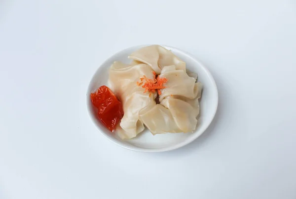Affordable version of dumplings, with a small packet of sauce. Isolated on white background