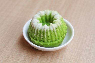 Putu ayu, Endonezya 'dan geleneksel bir aperatif. Hindistancevizi rendelenmiş kek. Küçük bir tabakta. Ahşap arkaplan.