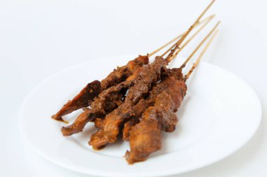 Fıstık soslu tavuk kanadı, bambu şiş. Endonezya geleneksel yemekleri. Beyaz bir tabakta. Beyaz arkaplanda izole