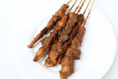 Fıstık soslu tavuk kanadı, bambu şiş. Endonezya geleneksel yemekleri. Beyaz bir tabakta. Beyaz arkaplanda izole