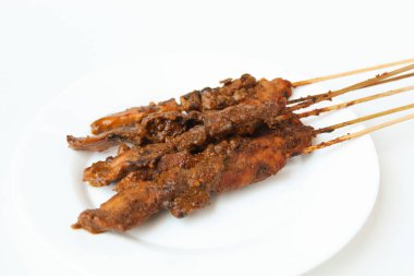 Fıstık soslu tavuk kanadı, bambu şiş. Endonezya geleneksel yemekleri. Beyaz bir tabakta. Beyaz arkaplanda izole