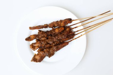 Fıstık soslu tavuk kanadı, bambu şiş. Endonezya geleneksel yemekleri. Beyaz bir tabakta. Beyaz arka planda izole edilmiş. Düz ya da üst görünüm