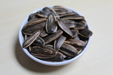 Küçük bir kasede ayçiçeği tohumu yığını. Çizgili kabuklu ayçiçeği çekirdeği.