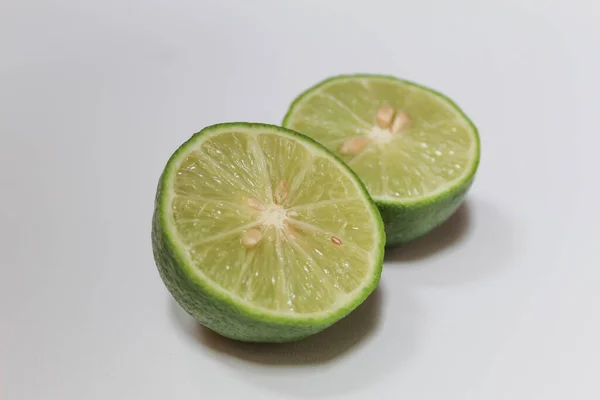 Limão Verde Cortado Pela Metade Isolado Sobre Fundo Branco — Fotografia de Stock