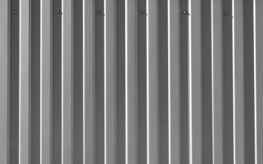 Duvara vidalanmış demirden yapılmış gri bir yaprak. Yüzleşmek ya da çatı malzemesi yapmak. Düz olmayan çelik arkaplan, metin için alanı kopyala.