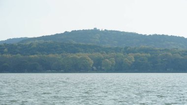 Güneşli bir günde panoramik manzara göle bakıyor.