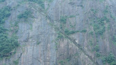 Yeşil ormanı olan güzel dağlar ve Çin kırsalının arka planında küçük bir köy.