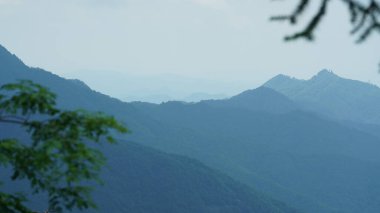 Yeşil ormanı olan güzel dağlar ve Çin kırsalının arka planında küçük bir köy.
