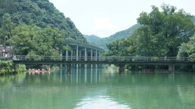 Çin 'in kırsal kesimindeki yeşil dağlarla çevrili güzel göl manzaraları.
