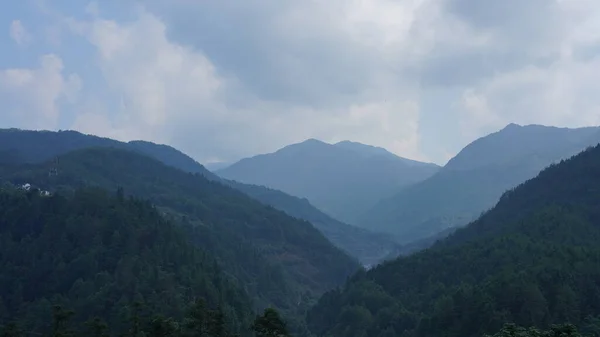 中国の田舎の背景として緑の森と小さな村と美しい山の風景 — ストック写真
