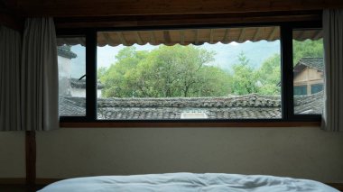 Pencere manzarası eski ahşap bir Çin binasından dışarı bakıyor.