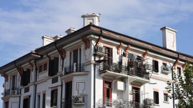 Arkaplan olarak sıcak güneş ışığı ve mavi gökyüzü olan eski ve tarihi bir bina manzarası