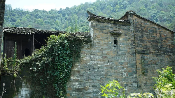 Güzel Çin kır köyü manzarası, doğal çevreyle çevrili eski geleneksel binalar.