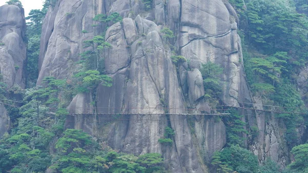 緑の森と中国の田舎の崖の顔に沿って構築された板道路と美しい山々の風景 — ストック写真