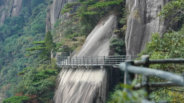 緑の森と中国の田舎の崖の顔に沿って構築された板道路と美しい山々の風景 — ストック写真