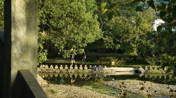 Two People Walking River Stone Bridge Cross Water — Stock Photo, Image