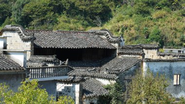 Klasik mimari ve taze yeşil ağaçların arka planda olduğu güzel geleneksel Çin köyü manzarası.
