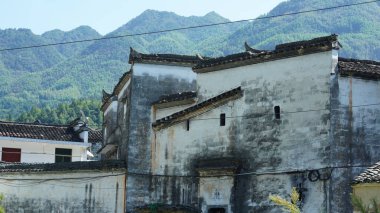 Klasik mimari ve taze yeşil ağaçların arka planda olduğu güzel geleneksel Çin köyü manzarası.
