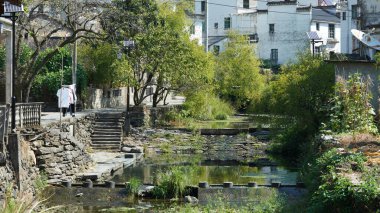 Klasik mimari ve taze yeşil ağaçların arka planda olduğu güzel geleneksel Çin köyü manzarası.