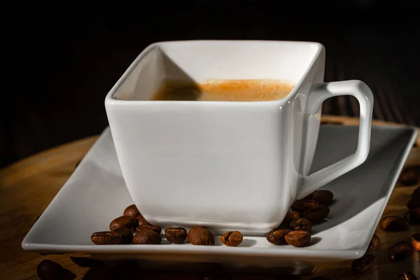 Taza blanca y platillo de café expreso de cerca sobre un fondo oscuro. Café expreso negro. — Foto de Stock