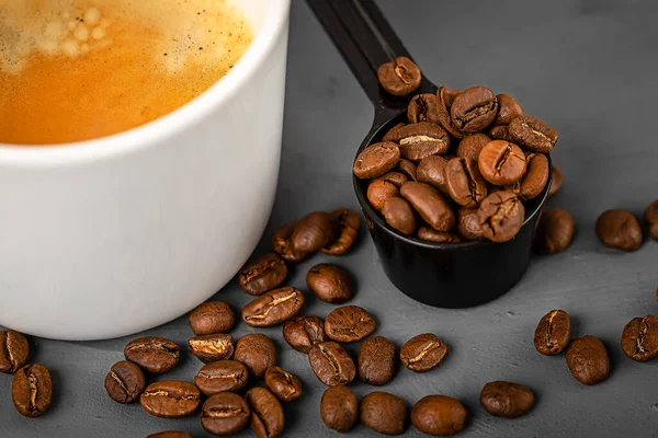 Λευκό φλιτζάνι καφέ εσπρέσο και κόκκους καφέ από κοντά. Προετοιμασία του καφέ. — Φωτογραφία Αρχείου