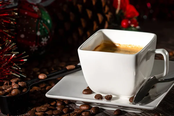 散在するコーヒー豆の背景にエスプレッソコーヒーの白いカップとソーサー — ストック写真