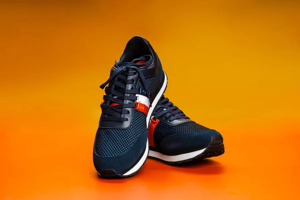 Israel. Rishon Lezion 05 14 2022. New Pierre Cardin sneakers on an orange background. Mens sports shoes. A pair of sports shoes. Sport. —  Fotos de Stock