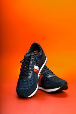 İsrail. Rishon Lezion 05 14 2022. Turuncu arka planda yeni Pierre Cardin ayakkabıları. Erkek spor ayakkabıları. Bir çift spor ayakkabı..