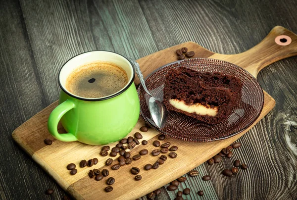 木製のテーブルの上にチョコレートケーキとコーヒーの緑のカップ — ストック写真