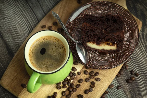 木製のテーブルの上にチョコレートケーキとコーヒーの緑のカップ 上からの眺め — ストック写真