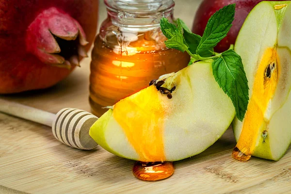 Rosh Hashanah. Pomegranate, apple and honey close-up, traditional food for Jewish New Year celebration, Rosh Hashanah. Holidays.