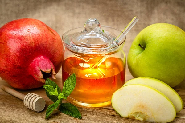 Rosh Hashanah. Pomegranate, apple and honey close-up, traditional food for Jewish New Year celebration, Rosh Hashanah. Holidays.