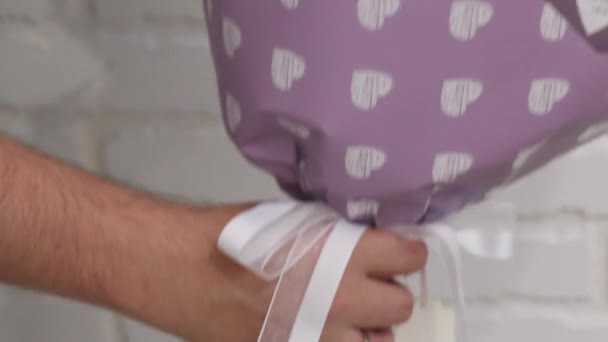 一个男人展示了用手工纸包装的棉花糖花束 Zephyr玫瑰花 特写镜头 — 图库视频影像