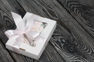 El yapımı ambalajlarda ev yapımı şekerlemeler. Gül şeklinde bir Zephyr. Çam ağacının arka planında.