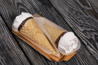 Ev yapımı marşmelovlar masa yüzeyine yayılır. Waffle külahında Zephyr. Bir gül şeklinde yapılmıştır. Yakın çekim..