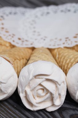 Ev yapımı marşmelovlar masa yüzeyine yayılır. Waffle külahında Zephyr. Bir gül şeklinde yapılmıştır. Yakın çekim..