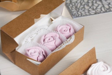 El yapımı ambalajlarda ev yapımı şekerlemeler. Gül şeklinde bir Zephyr. Çam ağacının arka planında.