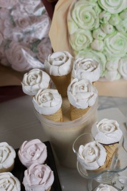 Ev yapımı marşmelovlar masa yüzeyine yayılır. Waffle külahında Zephyr. Bir gül şeklinde yapılmıştır. Yakın çekim..