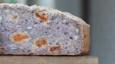 Bir somun fırınlanmış yeşil karabuğday ekmeği. Bir dilim ekmek görünür. Yakın çekim..